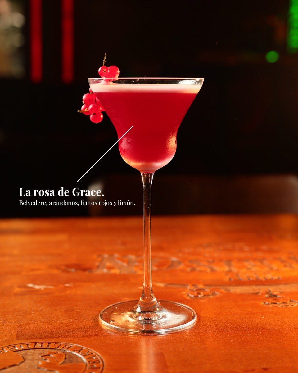 Dos amigas brindando con un Manhattan y un cóctel rojo con limón